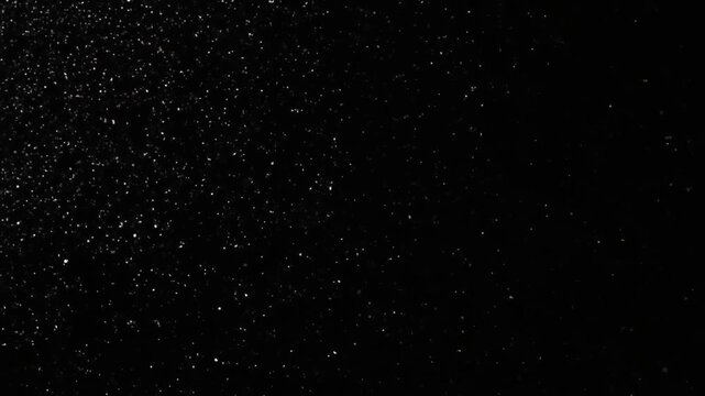 Glitter particles drifting through dark space