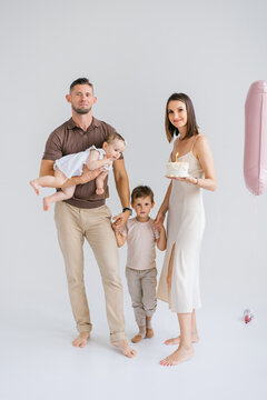 Family Standing Together with Birthday Cake and Balloon