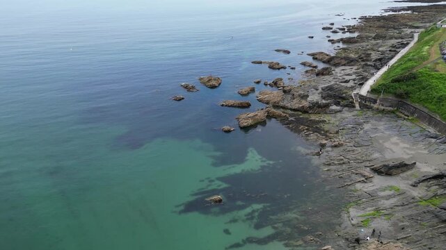 High Angle Footage of Beach and Ocean at Looe Town of England During Hot Sunny Day. Looe is a coastal town and civil parish in southeast Cornwall, England, United Kingdom.