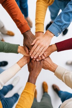 Diverse group stacking hands together in a vertical composition symbolizing teamwork, unity and mutual support
