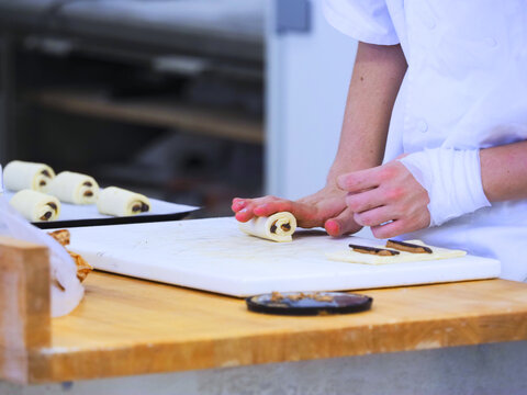 Geste de la pr&eacute;paration d'un pain au chocolat par un boulanger - Pr&eacute;paration de pain au chocolat