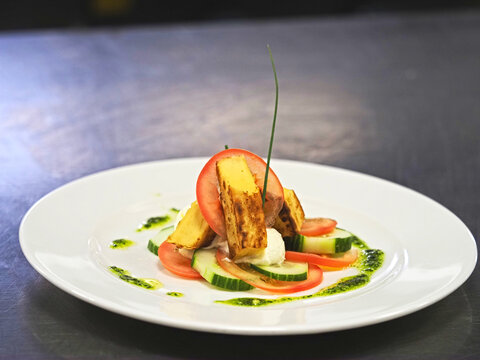 Plats gastronomiques servis &agrave; &ecirc;tre servi au restaurant - Vue du plat pr&eacute;par&eacute; qui est un plat de salade de concombre avec de la polenta avec un assaisonnement de pistou