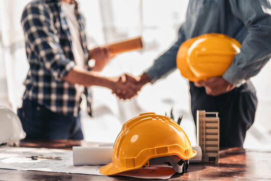 Two construction professionals shaking hands after project planning meeting
