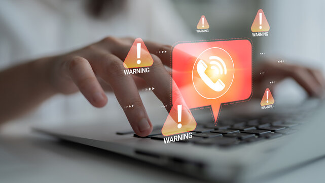 Close-up of a Person Hand Typing on a Laptop Keyboard with Warning Alerts Displayed for Cybersecurity Threats and Potential Scams in a Digital Environment Haptic.