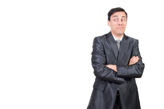 Mid shot of astonished male in formal suit looking aside while standing with crossed arms