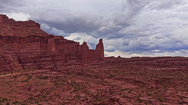 Dramatic aerial perspectives reveal towering mudstone spires and rugged fins below moody evening skies at Fisher Towers near Moab Utah