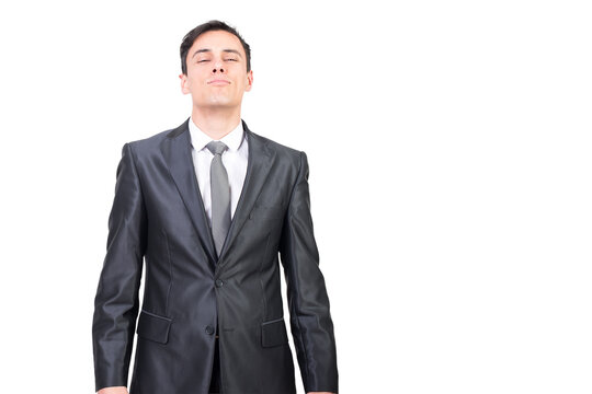 Confident handsome male entrepreneur in classy outfit with tie standing with closed eyes