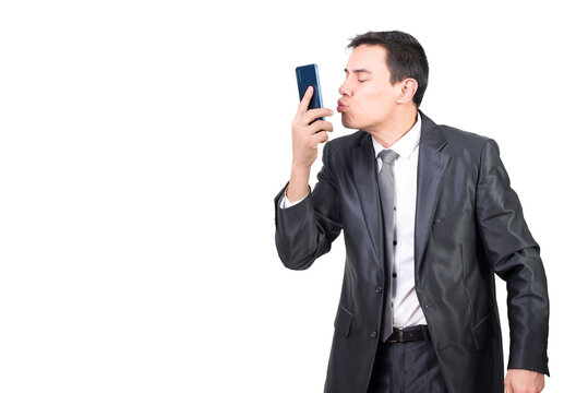 Mid shot of loving male in formal suit kissing modern cellphone