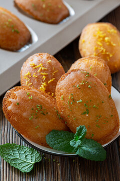 Golden fried pastries garnished with mint and citrus zest on wooden table