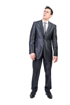 Full body of skeptic male grimacing and looking up while expressing mistrust on transparent background in studio