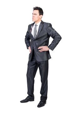 Full body of nervous and irritated male boss standing with hands on waist and looking at camera with frown face against transparent background