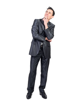 Full length of content pensive male entrepreneur in suit touching chin and looking up on transparent background