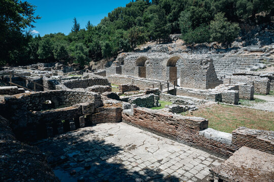 Ancient stone buildings ruins surrounded by trees  in National Park Butrint  in Albania.