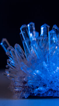 A mysterious, genuine crystal. The grown crystal rotates on an illuminated turntable. A scientific experiment and chemical study. A beautiful background or screensaver. Blue.