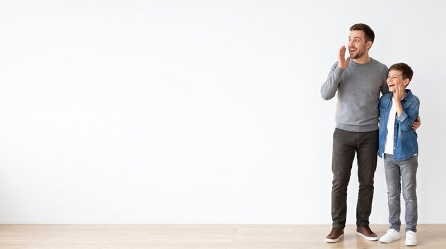 Father and son sharing a secret or calling out together with excitement against a plain white background