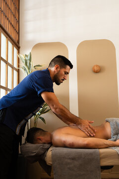 Massage Therapist Performing Professional Back Massage Treatment