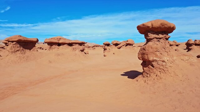 Unique mushroom-shaped sandstone hoodoos stand across the rugged desert badlands of Goblin Valley State Park in Utah