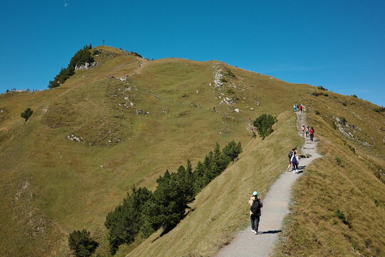 Hikers Walking along Stoos Ridge Trail in Swiss Alps