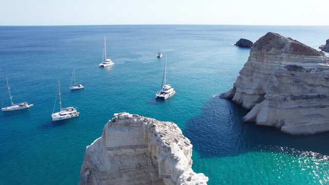 Sailboats gather in Kleftiko bay, a boat-access-only spot in Greece with white cliffs and blue waters