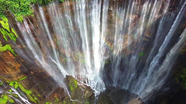 Close-Up Aerial Tilt Down of Tumpak Sewu Waterfall with Rainbow