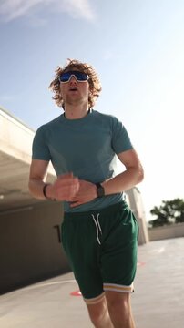 Vertical screen male runner urgently needs a toilet while running during outdoor workout showing discomfort and trying to continue his fitness training despite sudden urgency