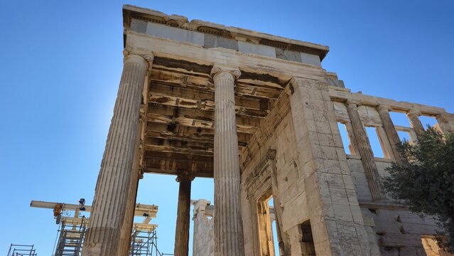 Athens, Greece - 26 June 2026. Low-angle view of the Erechtheion&rsquo;s north porch and west wall, showing Ionic columns, coffered ceiling and restoration equipment.