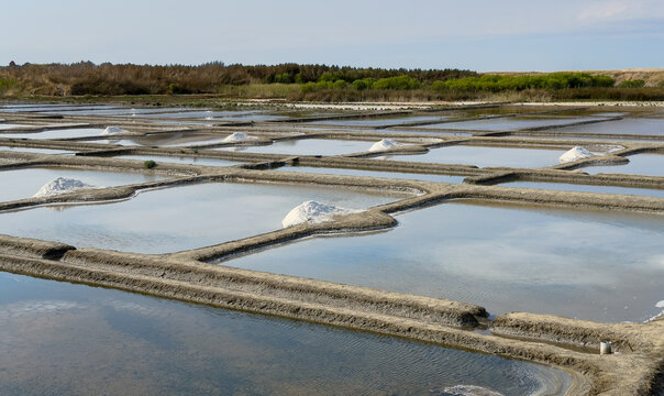 Salt pans with sea salt mounds and reflective water ponds