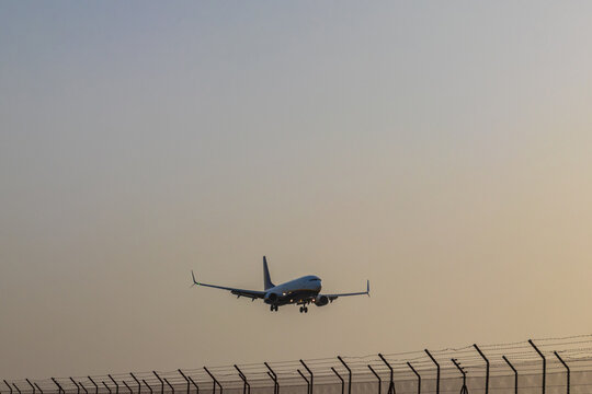 Commercial passenger airplane approaching landing at the runway airfield during calima haze