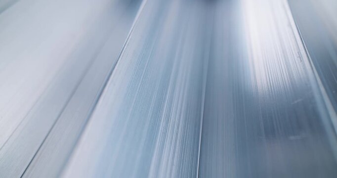 Macro view of golden oil softgel capsules on brushed metal conveyor pack for supplement medical product.