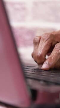 enior person typing on laptop keyboard close up - Old hands typing on laptop keyboard