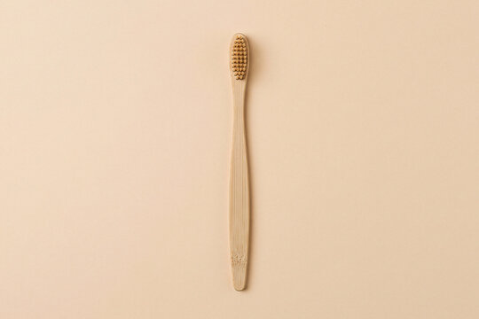 Eco friendly bamboo wood toothbrush isolated on a warm beige background