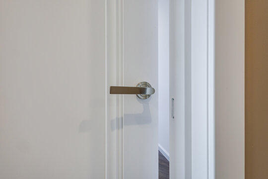 door handle on white wooden door in interior. Knob close-up elements. Door handle, fittings for interior design