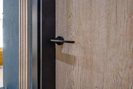 door handle on white wooden door in interior. Knob close-up elements. Door handle, fittings for interior design