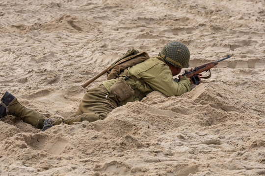 Historical reenactment of a World War II battle. An American infantryman during the fighting on the beach,