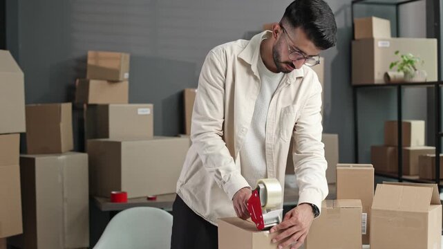 Young man seals package with care