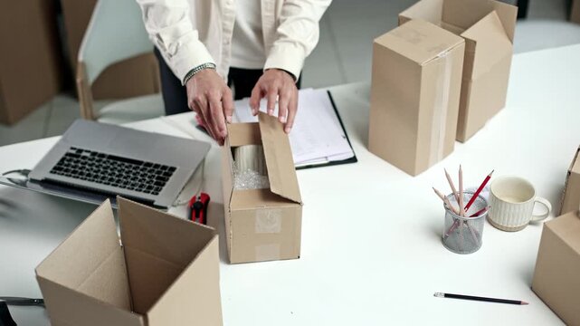 Person seals a package with red-handled scissors