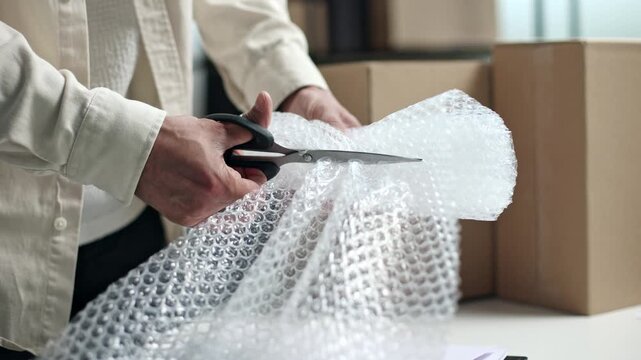 Person cuts bubble wrap with scissors