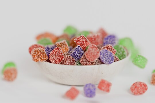 3d sugary gummy candies in a bowl, white background