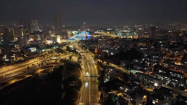 A time-lapse shot of traffic in Jerusalem, featuring high-rise buildings.