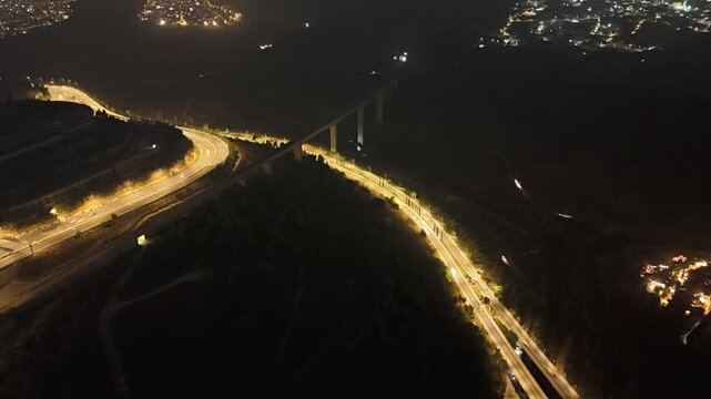 A time-lapse shot of traffic in Jerusalem featuring a suspended train bridge.