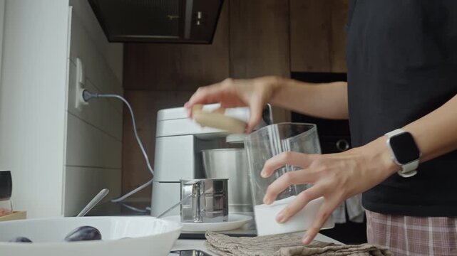 Woman measuring salt while preparing ingredients for baking