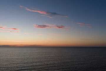 Obraz premium Aerial drone view of calm Baltic Sea water with light ripples under colorful sky with pink clouds after sunset in Estonia