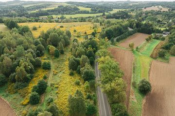 Panorama przedgórza sudeckiego, Zdjęcie z wysokości wykonane z użyciem drona. Pofałdowany teren pokryty jest uprawami i łąkami. Miejscami widać kępy drzew., zabudowania i drogi. © boguslavus
