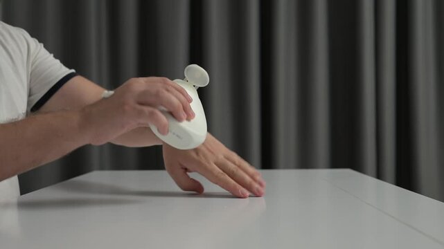 Close-up hands dispensing lotion into upright pump bottle on glossy white table with soft side light and gray curtains clean skincare product setup minimal studio