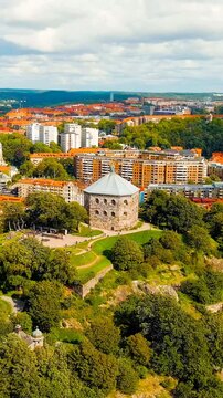 Vertical video. Gothenburg, Sweden. Skansen Kronan - A fortress on a hill with panoramic views of the city. Panorama of the city. Summer day. Cloudy weather. Drone footage. Rich colors