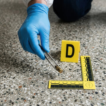 Forensic Investigator Collects Bullet Casing Evidence At Crime Scene