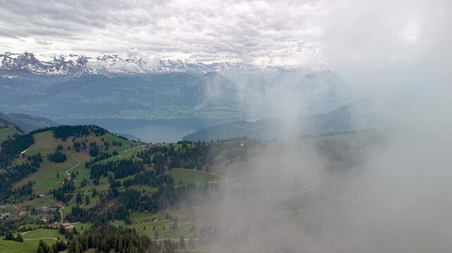 Aerial view of fog clearing over Swiss Alps and Lake Thun