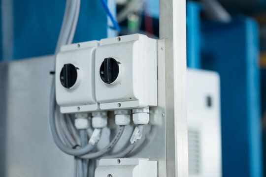 Pair of rotary electrical isolator switches in protective enclosures with cable glands, providing local power disconnection hardware for industrial machinery