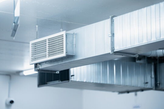 An exposed rectangular duct network carries a projecting ventilation grille near the ceiling, illustrating fabricated air handling components for building mechanical services