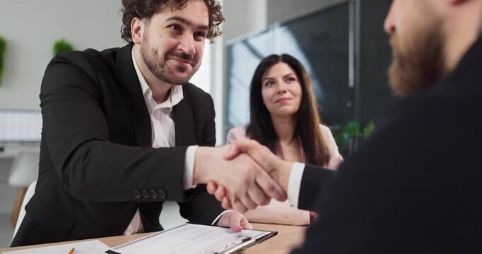 Interview handshake between recruiter and candidate in office. Professional meeting with documents signals successful hiring and trust for HR. Clear concept of agreement and employment.